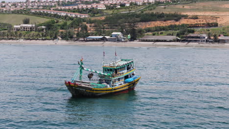 Big-Trawler-Commercial-Fishing-Boat-Rocking-Over-The-Famous-Fishing-Coast-Of-Mui-Ne,-Southeast-Vietnam