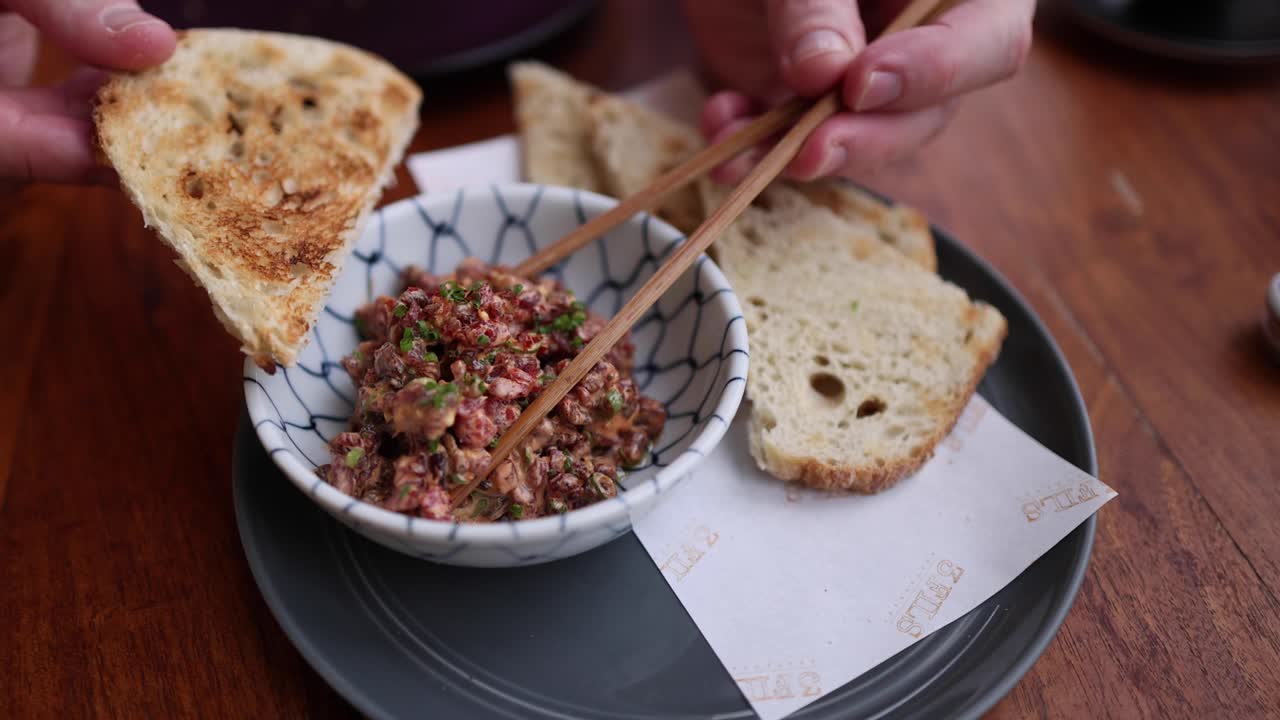 usando palillos para comer pan y platos picados