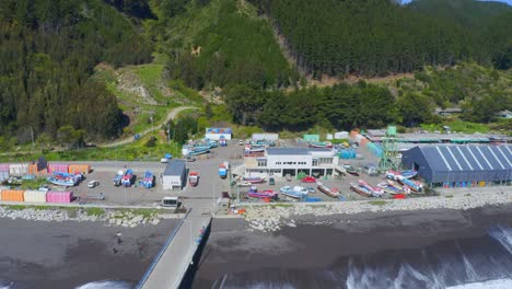 Puerto-O-Caleta-Meguellines,-Constitución-Chile-Drone-Tiro-Día-Soleado-Con-Barcos-De-Pesca-Saliendo