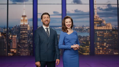 dos presentadores de noticias sonriendo transmitiendo noticias en un canal de televisión. presentadores sonrientes