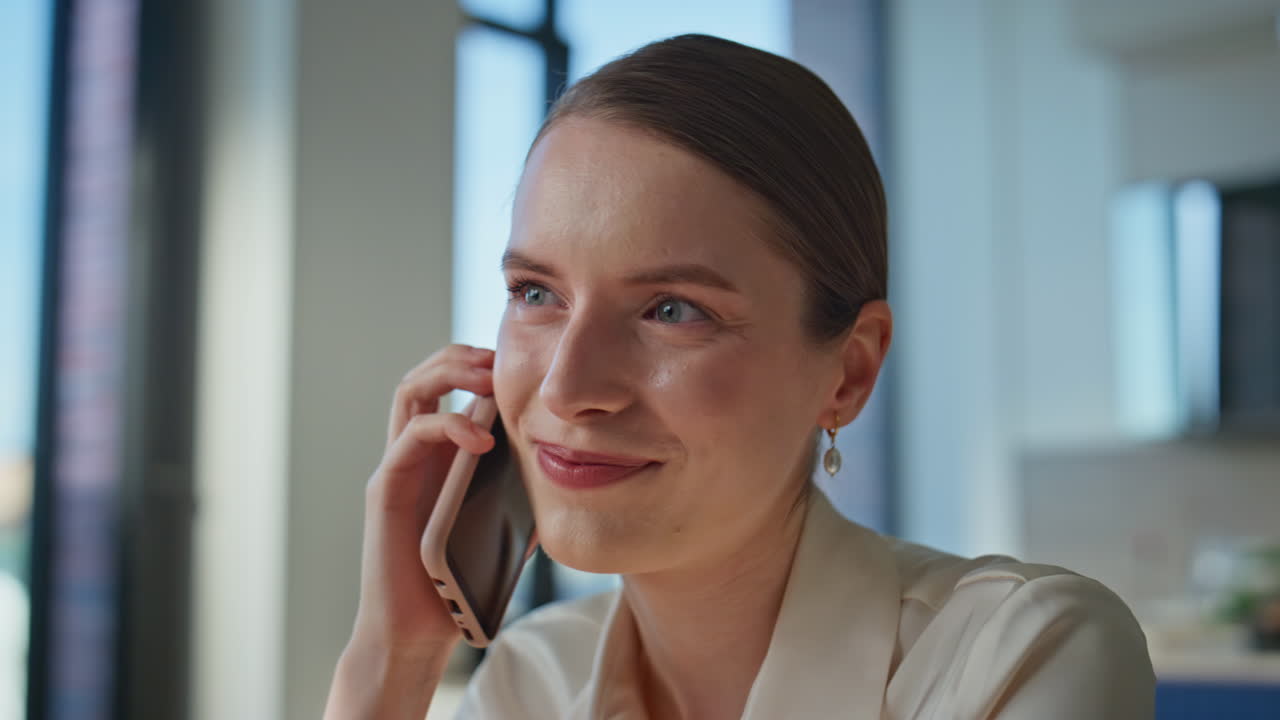 Smiling manager negotiating cellphone in professional office setting closeup