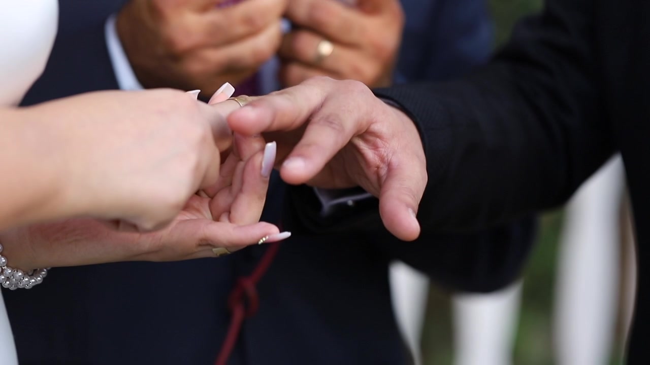 A bride wearing her groom's wedding ring
