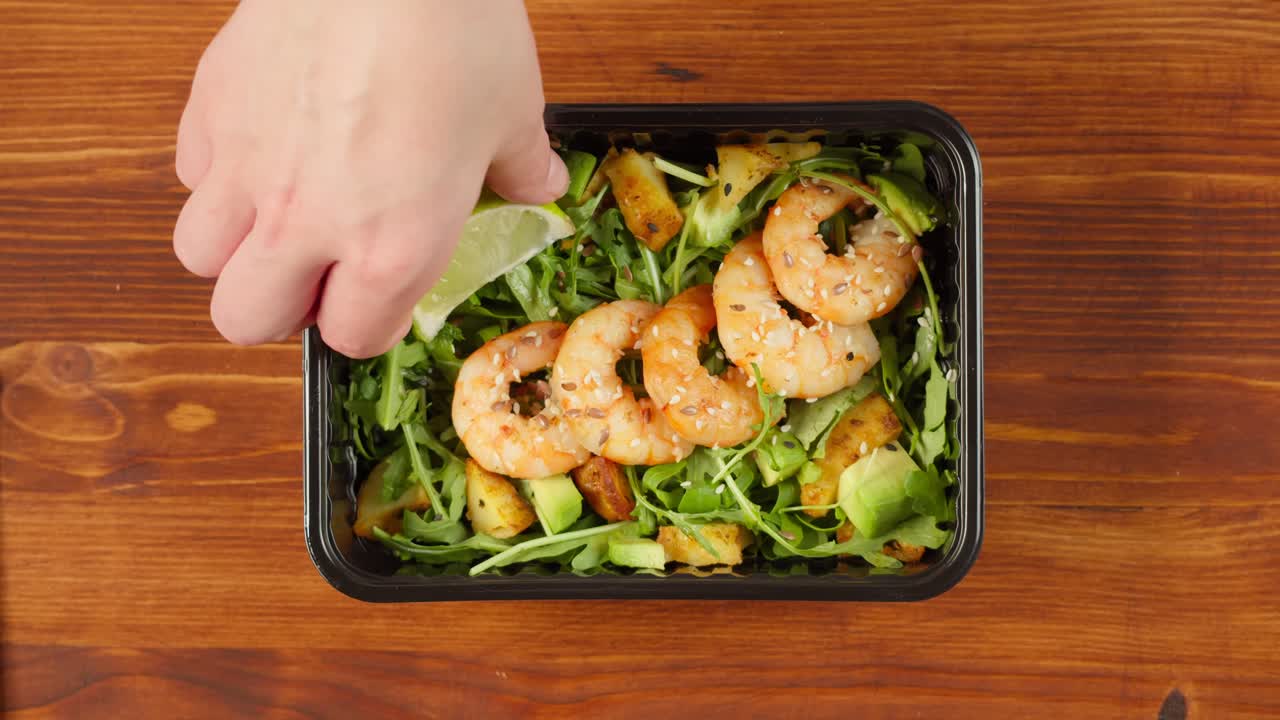 Preparazione di insalata di gamberi sana con avocado e rucola.