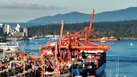 port crane unloading containers from ship docked at the terminal