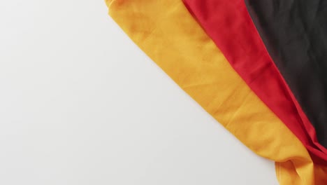 Video-of-creased-flag-of-germany-lying-on-white-background