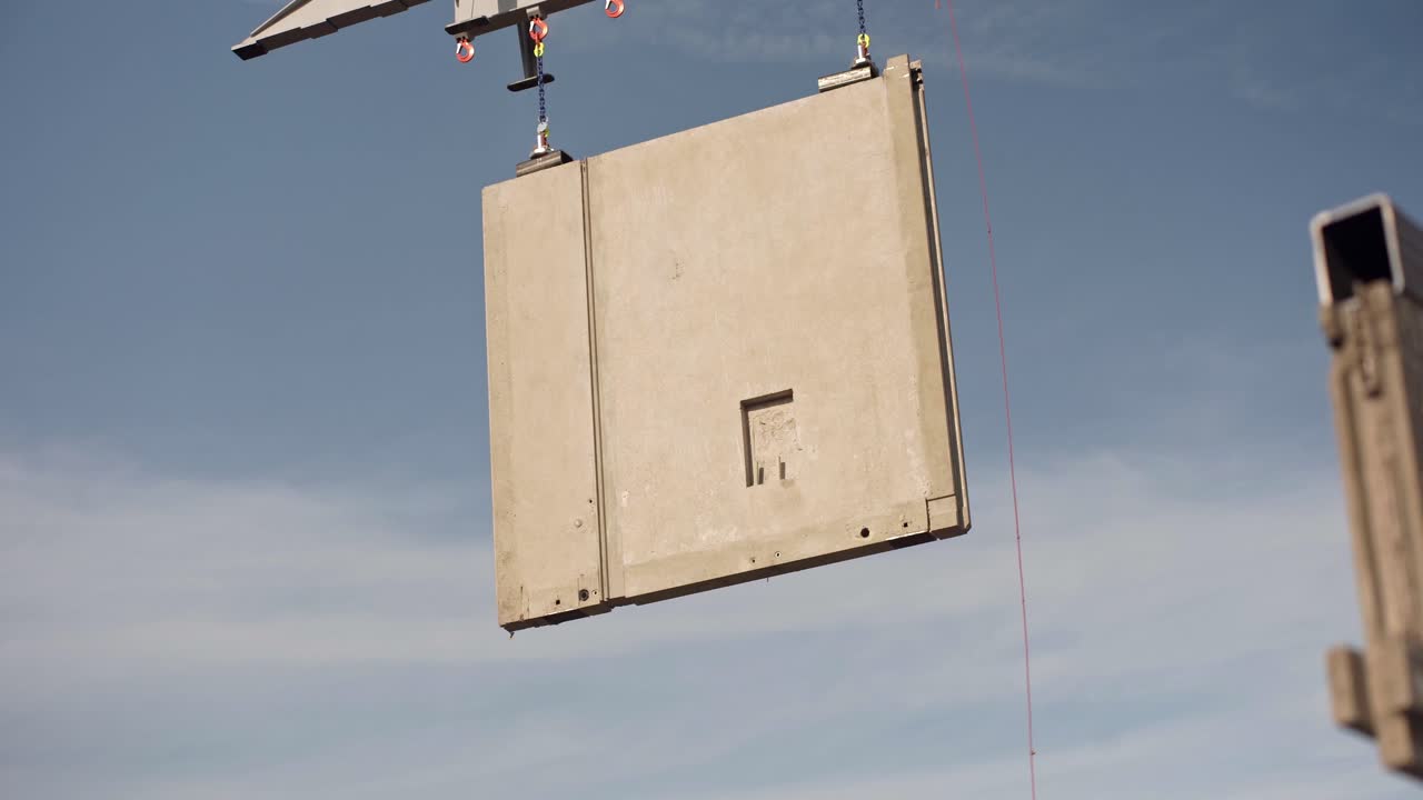 panel de construcción de hormigón movido en el aire por el estante de la grúa de construcción