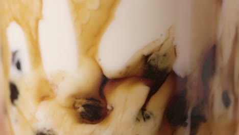 macro shot, blending pearl milk tea process, with tapioca balls at the bottom