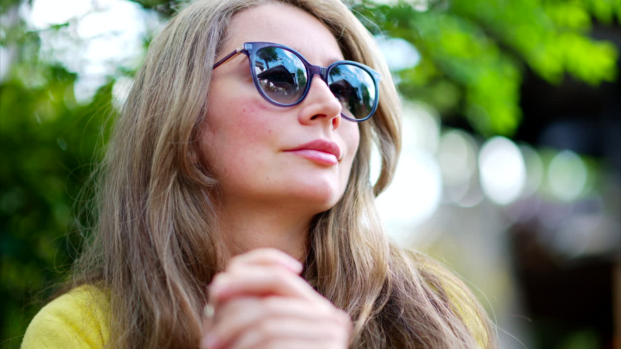 Woman putting on a pair of sunglasses outside