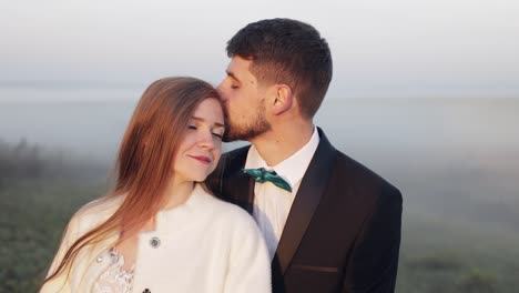 Newlyweds.-Caucasian-groom-with-bride-on-the-morning-field.-Fog.-Wedding-couple