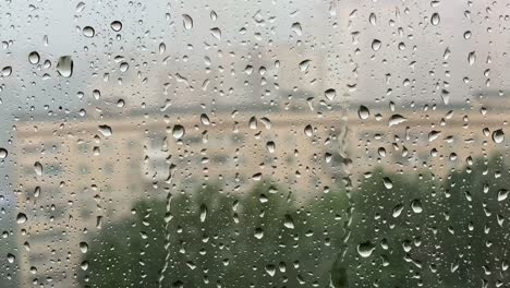 rainy summer. rain drops on window with blurred background. heavy rain storm, climate change concept.