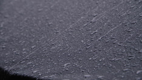 heavy rain on black waterproof textile. 4k