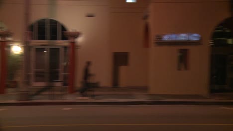 a car travels along a street at night in santa monica california as seen through the side window