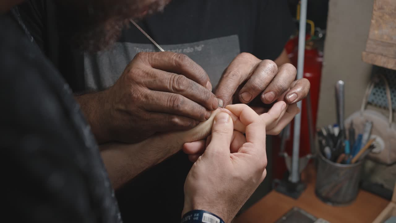 Helpful hand removing splinter from another person's hand - workshop