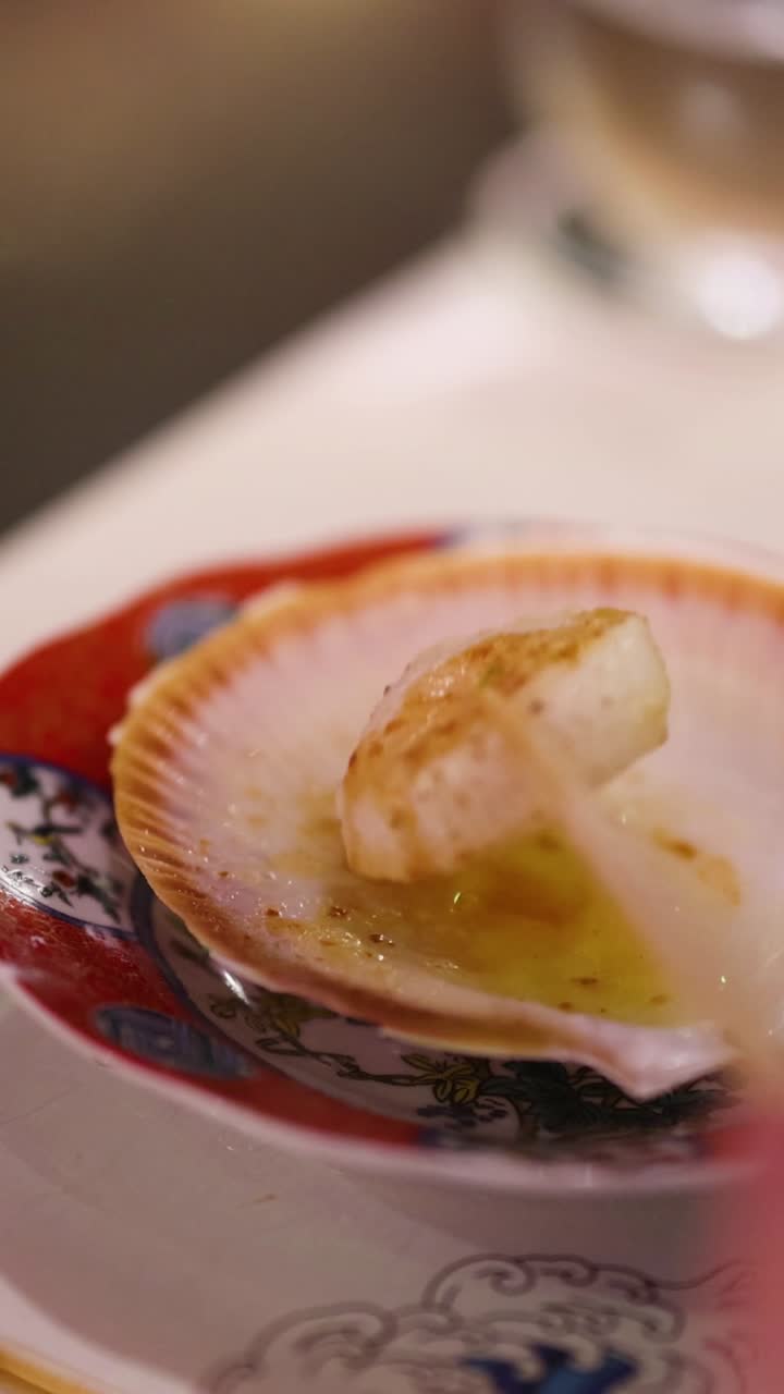 Close-up of a scallop being seared with a torch