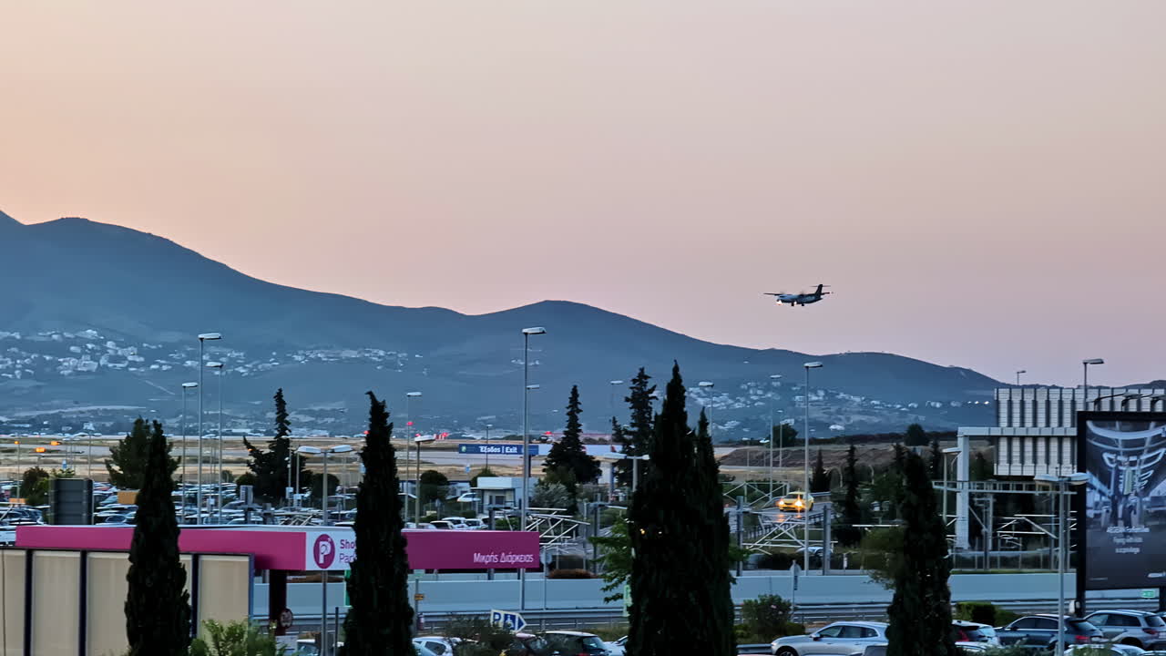 Airplane flying over an airport at dusk