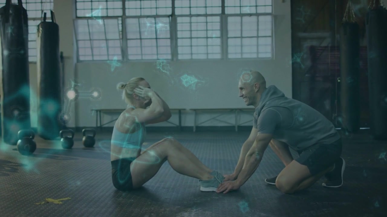 Kvinnelig deltaker tar situps mens en mannlig trener holder føttene, med et blått overlegg som viser repetisjoner for fitness.