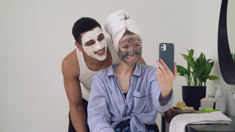 interracial couple with facial mask taking a selfie