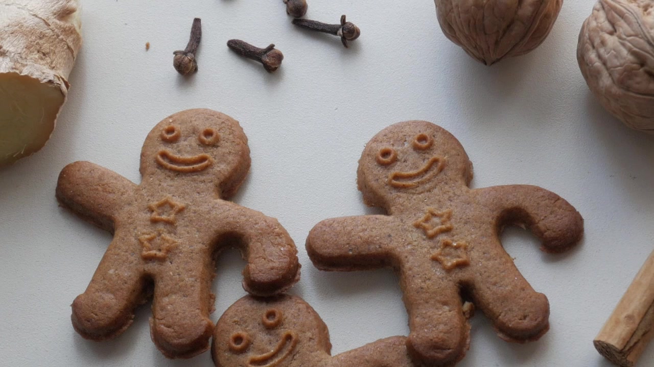 Biscotti di pan di zenzero con spezie su sfondo bianco evocano un'atmosfera festosa e accogliente