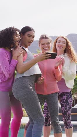 video vertical de un grupo feliz de amigos diversos tomando selfies