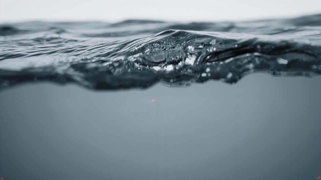 Light breeze stirring ocean surface, forming and moving low crests at sea with bubbles, horizon