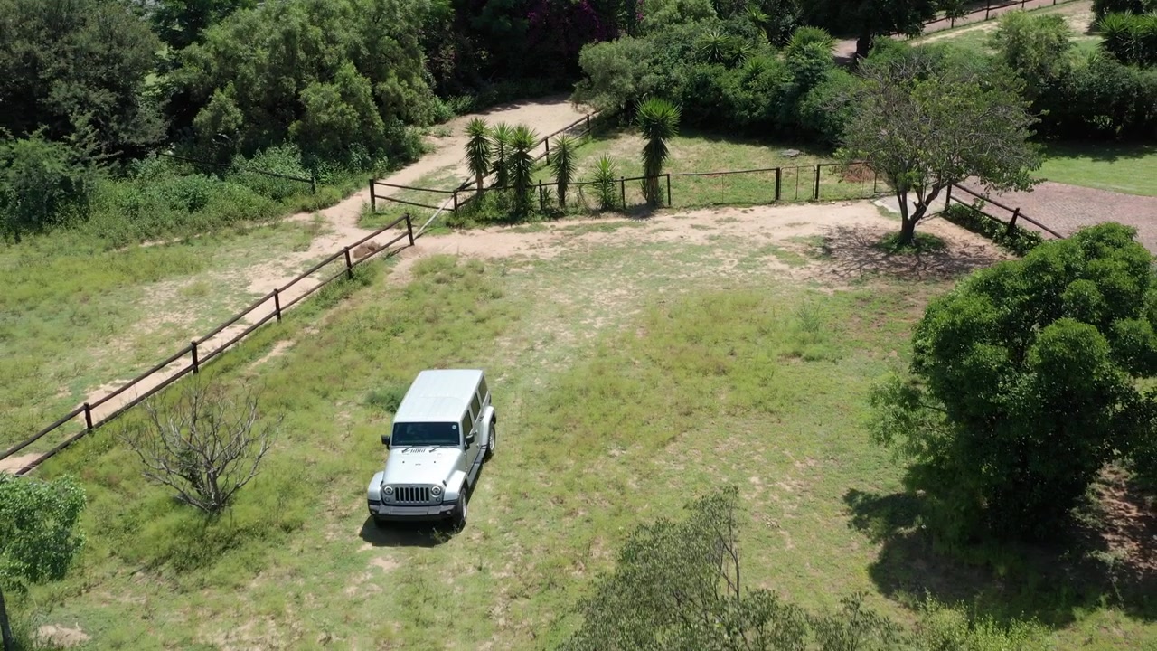 Jeep che attraversa un campo d'erba in una fattoria, avventura fuoristrada, ripresa aerea