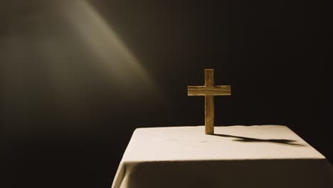 concepto religioso filmado con cruz de madera en el altar en un charco de luz