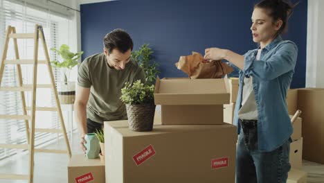 video of couple packing things to boxes while moving house.