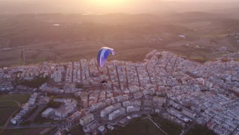 Gleitschirm-Trike,-Das-Bei-Hellem-Sonnenuntergang-Frei-über-Ginosa-In-Italien-Fliegt,-Antenne