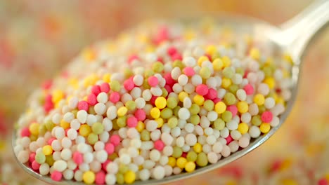 close-up shot of taking a spoon full of colorful sugar sprinkles dots