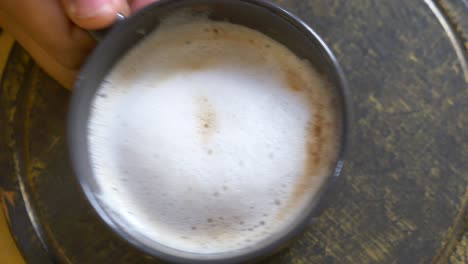 cappuccino in a cup on a wooden plate