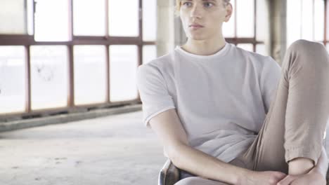 young trendy man sitting on chair in hall