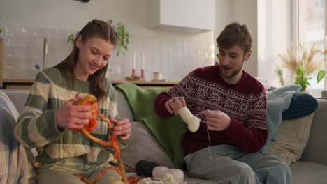 couple knitting together on the couch