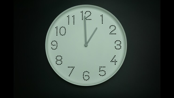Time lapse white wall clock tell the time 2 p.m.