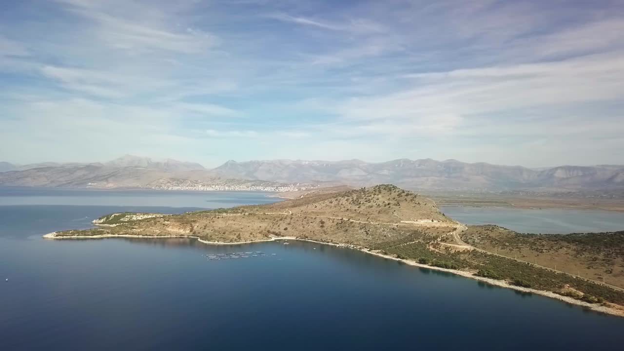 Drone fly overlooking Ksamil and the Albanian Riviera on a perfect blue skies summer day and the mountains in the background
