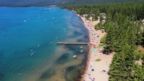 Luftaufnahme-Von-Menschen,-Die-Sich-An-Einem-Sandstrand-Entspannen,-Der-Von-Einem-Kiefernwald-In-Lake-Tahoe-Umgeben-Ist