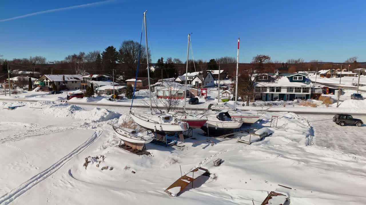 Vista aérea de drone de iates em Gosport em Brighton, Ontário, com paisagem congelada coberta de neve sob um céu azul ensolarado de inverno