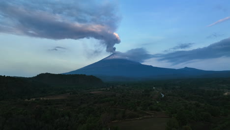 drone shot rising over fields, toward the popocatepetl volcano, evening in mexico