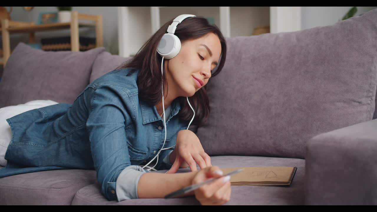 Woman Relaxing and Drawing on a Couch