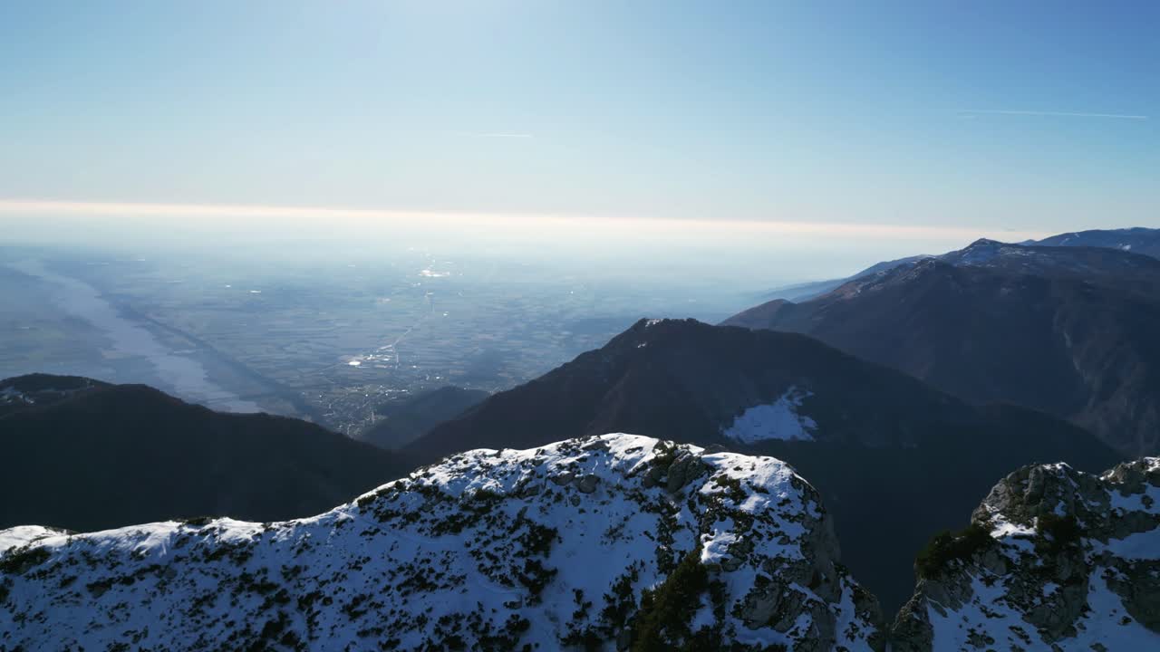 Filmato aereo con drone sopra Monte Raut, Italia: limpida giornata di dicembre con creste illuminate dal sole e pendii innevati in ombra. Ideale per filmato video in stock naturalistico invernale, alpino e cinematografico.