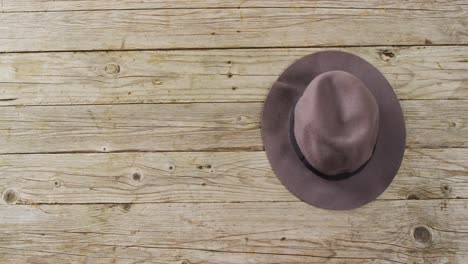 Video-of-close-up-of-hat-on-wooden-background