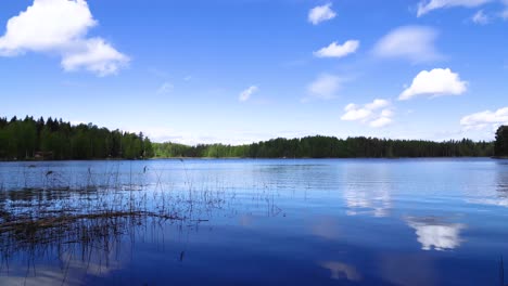 wonderful time lapse from the water of a lake and the clouds passing by in the blue sky