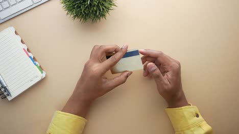 person holding a credit card on a desk