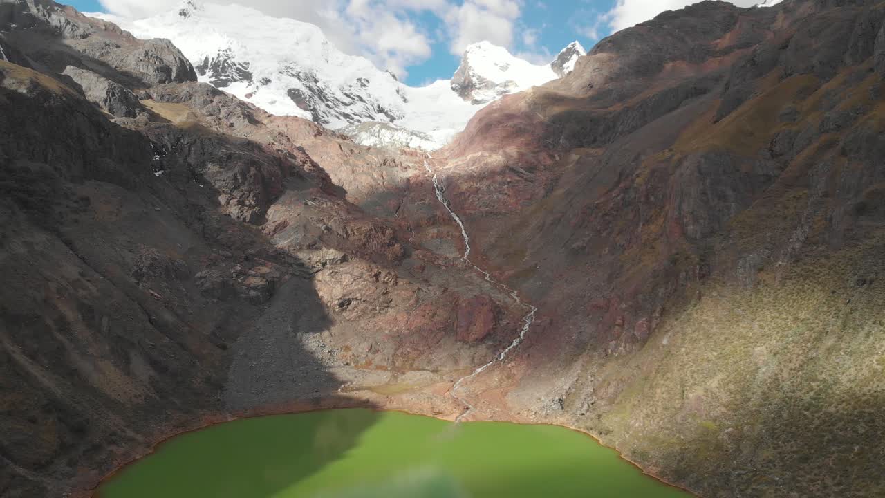Lago verde con fiume e montagne glaciali, di fronte alle Ande peruviane. Effetti del riscaldamento globale.