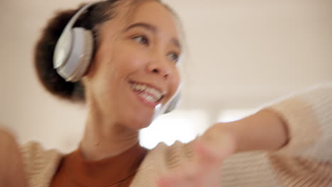 Young-woman,-headphones-and-dancing-in-home-living