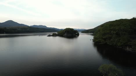 Flying-over-small-island-at-Coniston-Water,-in-the-Lake-District,-Northern-England