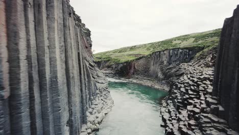 tiro de dron volando dentro del cañón studlagil en islandia 4k