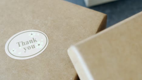 close up of a brown gift box with a thank you sticker