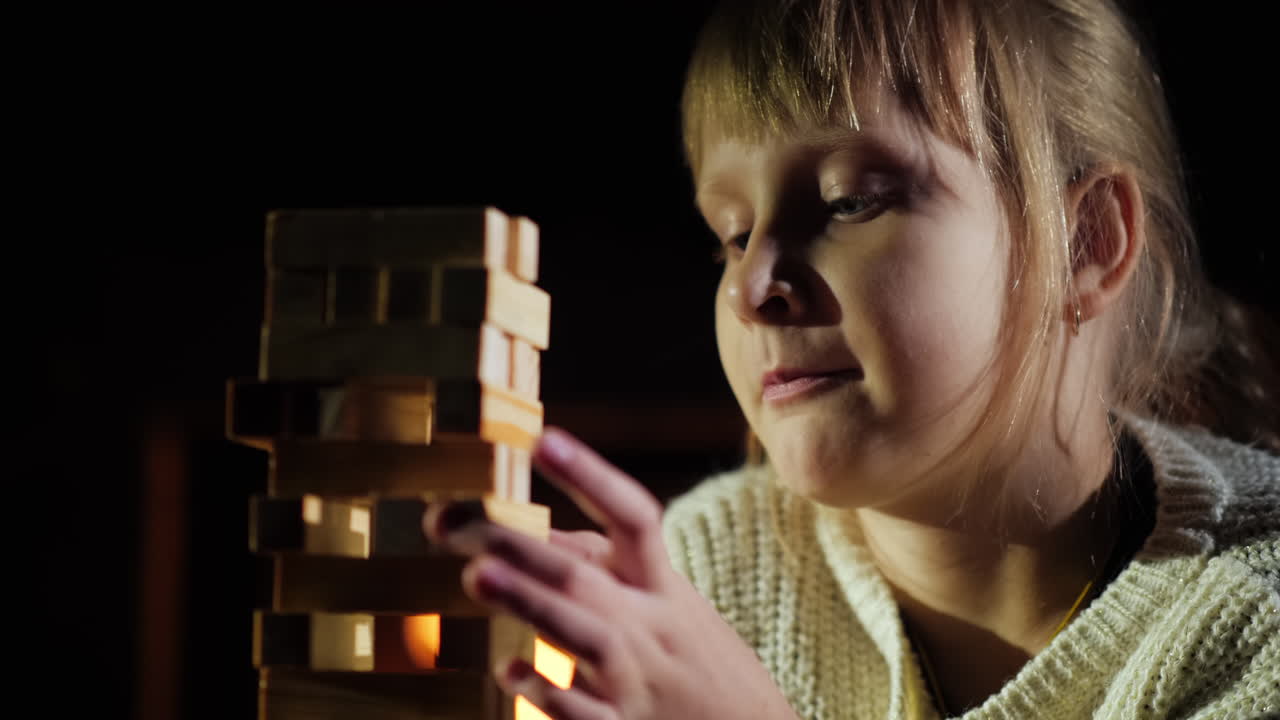 retrato de un niño jugando un juego donde necesitas sacar bloques de madera de la torre