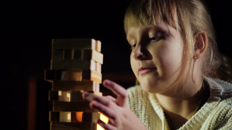 Retrato-De-Un-Niño-Jugando-Un-Juego-En-El-Que-Debes-Sacar-Bloques-De-Madera-De-La-Torre