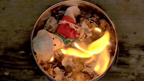 sorcery witchcraft voodoo ritual with a doll being burned inside a bowl with fire to make a curse spell with him.  muñeco de año viejo